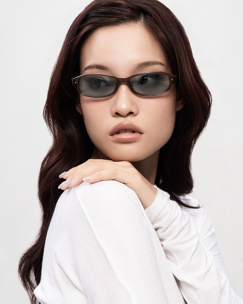A model in SEEYAA! tinted acetate sunglasses, hand resting on her shoulder.