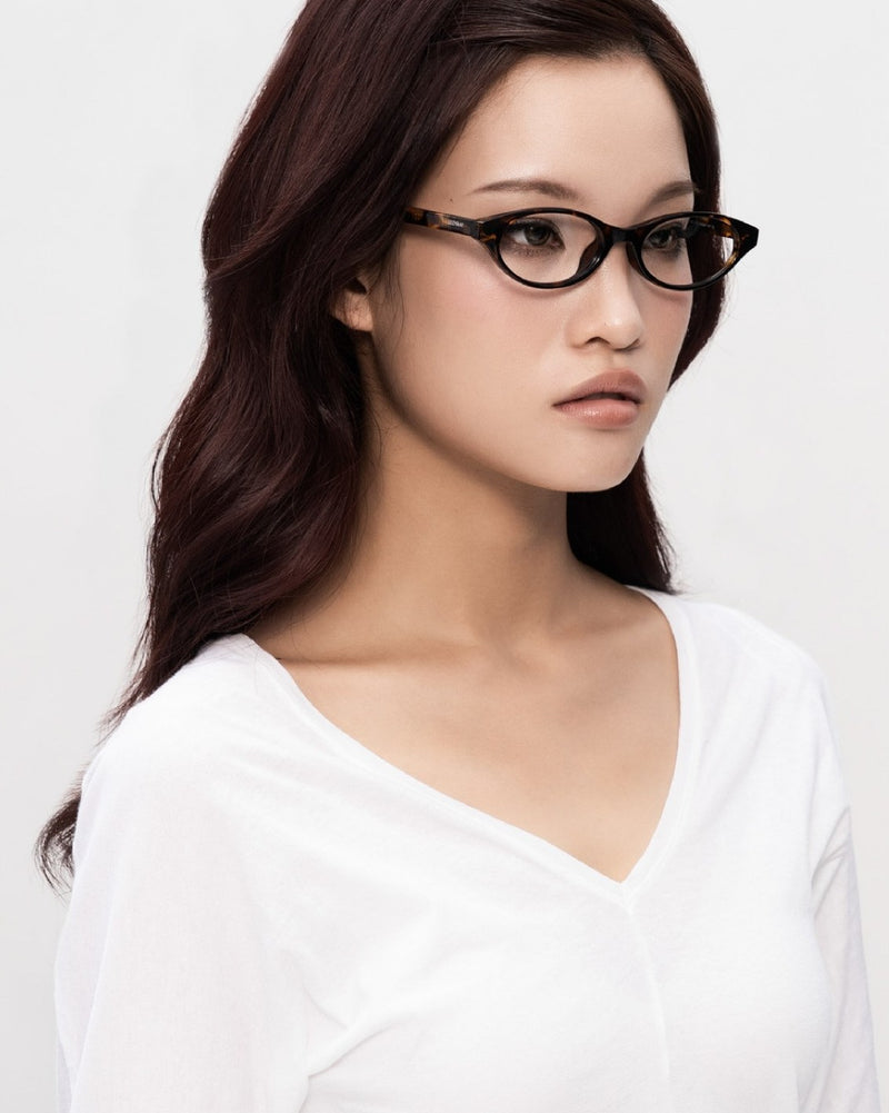A model in SEEYAA! black acetate optical frames, face turned slightly to the side.